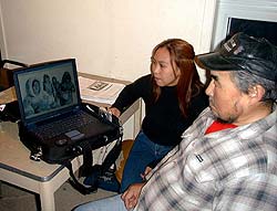 Photo of fieldworker Sheba Awa showing photographs to Elder Eugen Ipkangnak