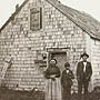 Photo d'une famille en avant de leur maison à Whycocomagh en Nouvelle-Écosse, en 1911