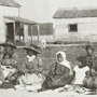 Photo d'un groupe d'hommes, de femmes et d'enfants autochtones assis sur le sol à l'occasion d'un festin à Mattagami, juillet 1906