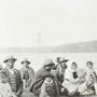 Photo d'un groupe d'hommes, de femmes et d'enfants autochtones assis sur le sol à l'occasion d'un festin à Mattagami, juillet 1906