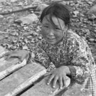 Photograph of an Inuit girl standing behind a dock, unknown location, Nunavut, 1945