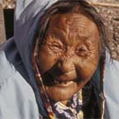 Photograph of a smiling elderly Inuit woman wearing a blue jacket, Arctic Bay (Ikpiarjuk/Tuninirusiq), Nunavut, circa 1974