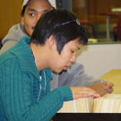 Photograph of Corenna Nuyalia (front) from Iqaluit (formerly Frobisher Bay) and Thomas Aggark (back) of Arviat (formerly Eskimo Point), students from Nunavut Sivuniksavut Training Program, seaching the card catalogues at Library and Archives Canada, Ottawa, October 2005